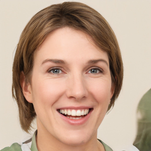 Joyful white young-adult female with medium  brown hair and green eyes