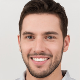 Joyful white young-adult male with short  brown hair and brown eyes