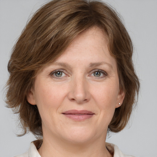 Joyful white adult female with medium  brown hair and grey eyes