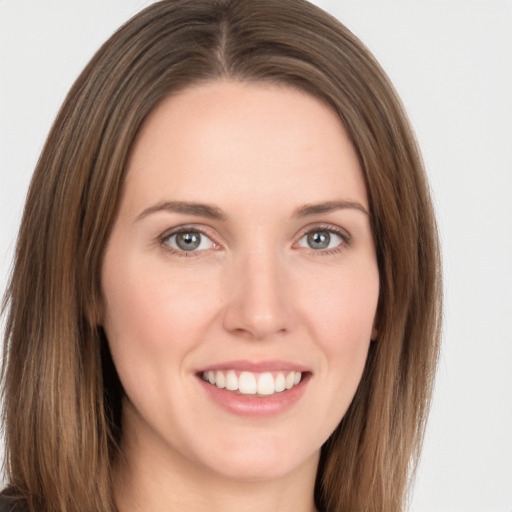 Joyful white young-adult female with long  brown hair and grey eyes