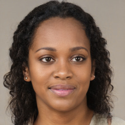 Joyful black young-adult female with long  brown hair and brown eyes