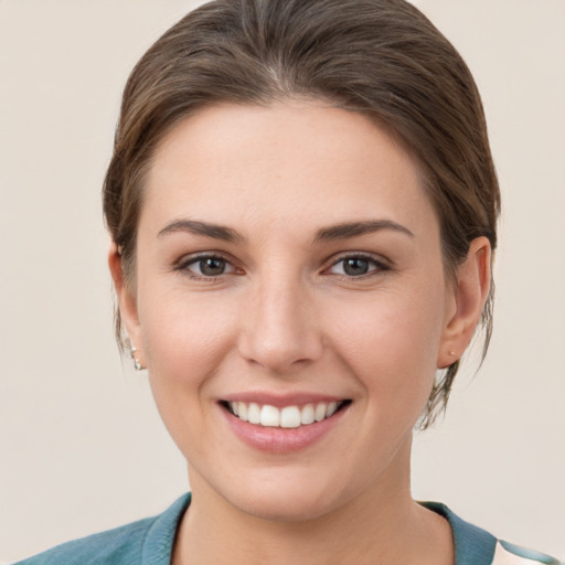 Joyful white young-adult female with medium  brown hair and grey eyes