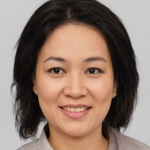 Joyful asian young-adult female with medium  brown hair and brown eyes
