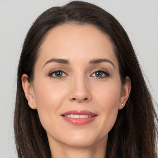 Joyful white young-adult female with long  brown hair and brown eyes