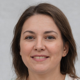 Joyful white adult female with long  brown hair and brown eyes