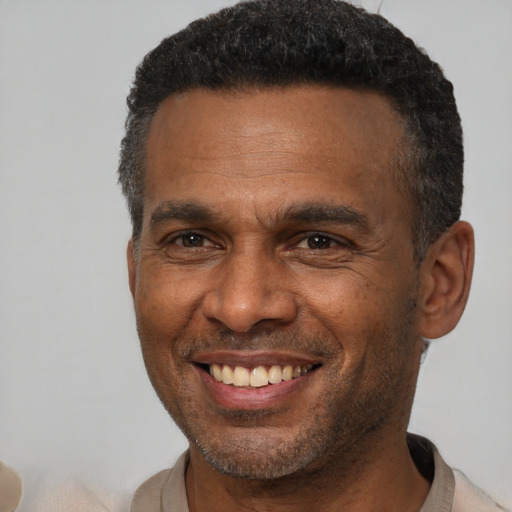 Joyful black adult male with short  brown hair and brown eyes