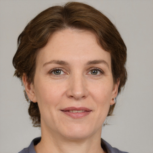 Joyful white adult female with medium  brown hair and grey eyes