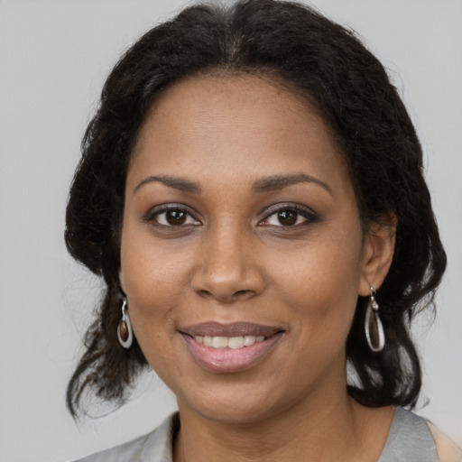 Joyful black young-adult female with medium  brown hair and brown eyes