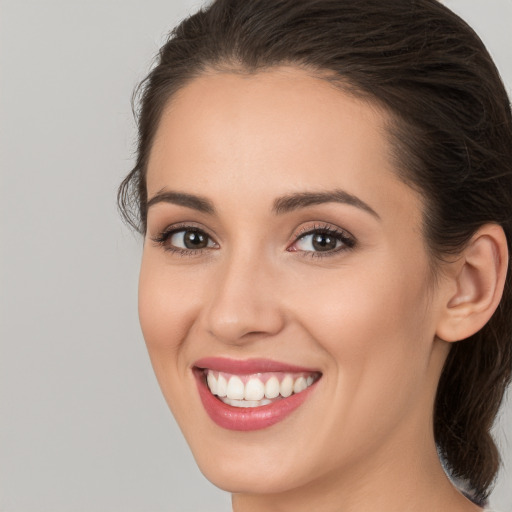 Joyful white young-adult female with long  brown hair and brown eyes