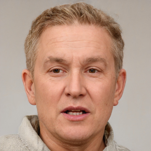 Joyful white middle-aged male with short  brown hair and blue eyes