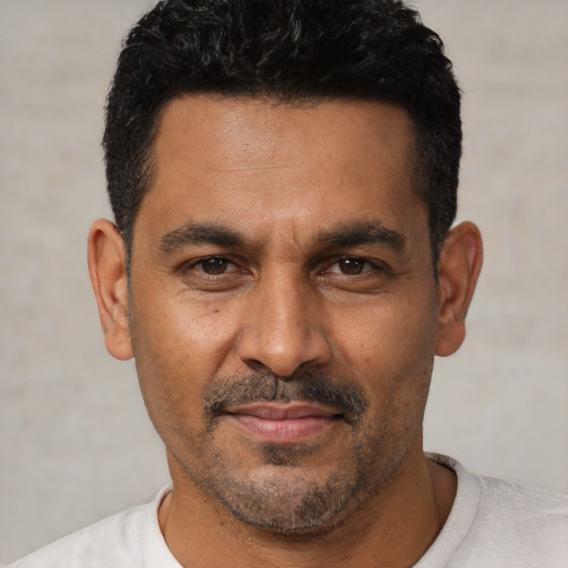 Joyful latino adult male with short  black hair and brown eyes