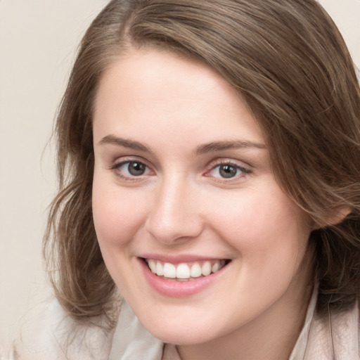 Joyful white young-adult female with medium  brown hair and grey eyes