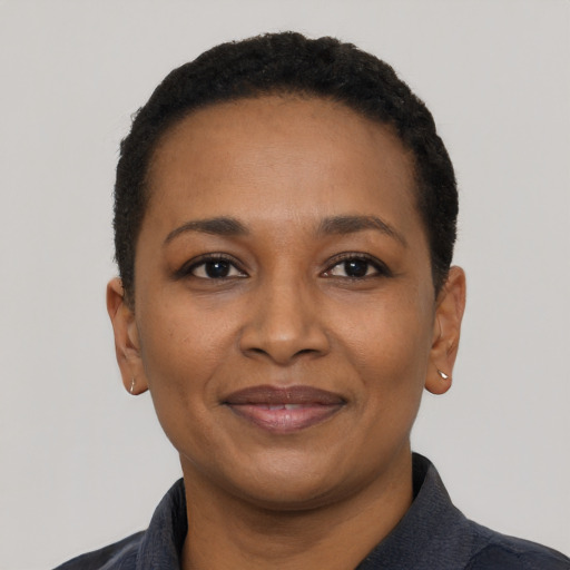 Joyful black adult female with short  black hair and brown eyes