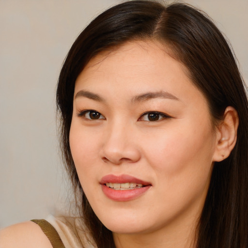 Joyful asian young-adult female with long  brown hair and brown eyes