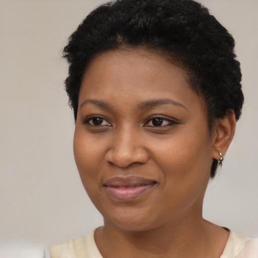 Joyful black young-adult female with short  black hair and brown eyes