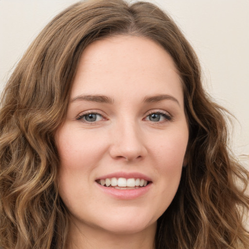 Joyful white young-adult female with long  brown hair and green eyes