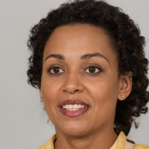 Joyful black adult female with medium  brown hair and brown eyes