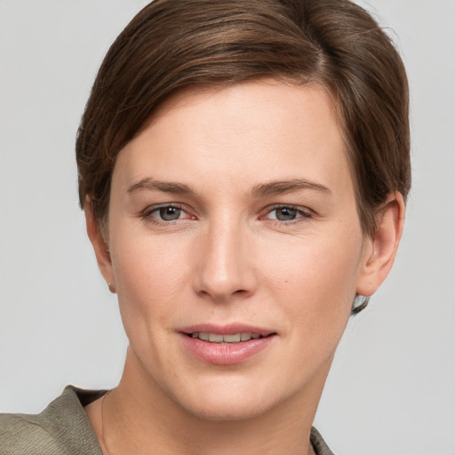 Joyful white young-adult female with short  brown hair and grey eyes