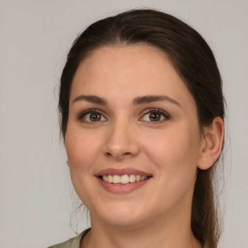 Joyful white young-adult female with long  brown hair and brown eyes