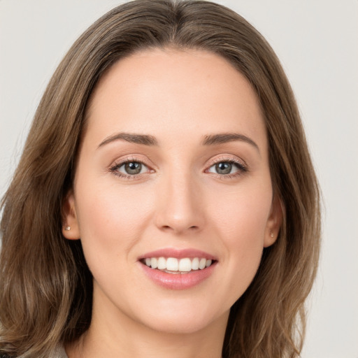 Joyful white young-adult female with long  brown hair and green eyes