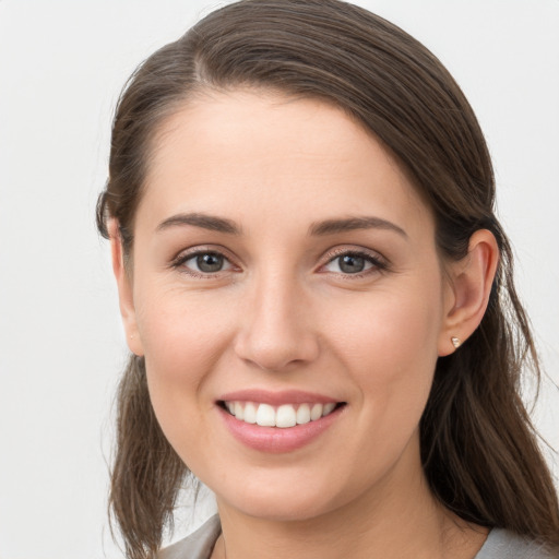 Joyful white young-adult female with long  brown hair and brown eyes