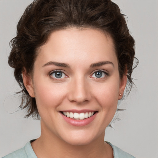 Joyful white young-adult female with medium  brown hair and green eyes