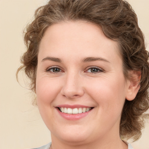 Joyful white young-adult female with medium  brown hair and green eyes