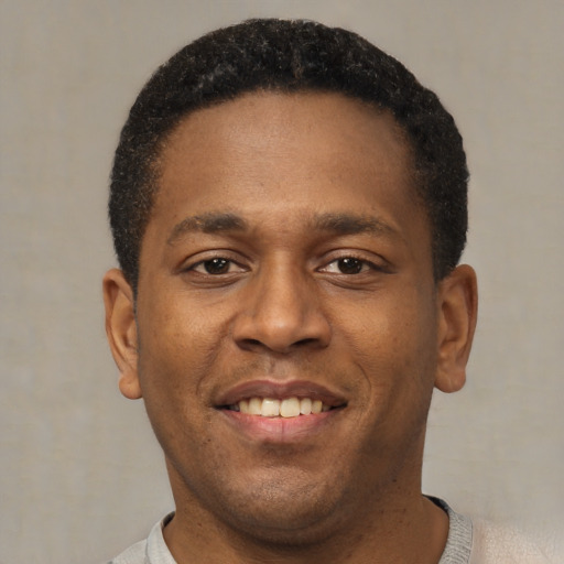 Joyful latino young-adult male with short  brown hair and brown eyes