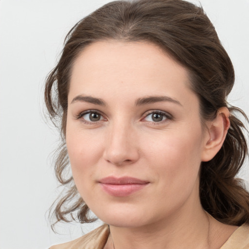 Joyful white young-adult female with medium  brown hair and grey eyes