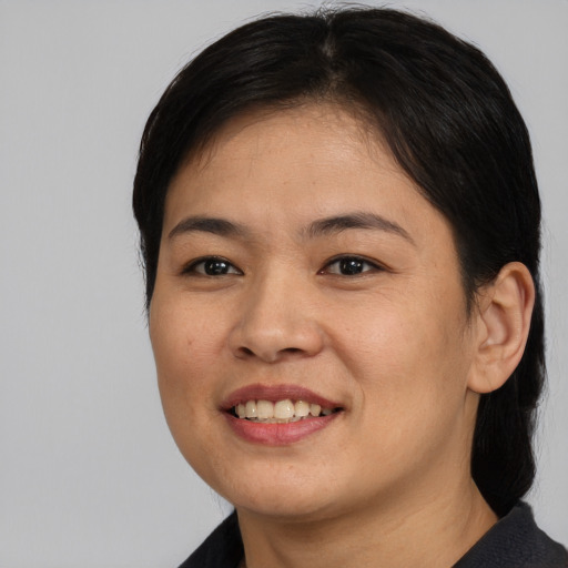 Joyful asian young-adult female with medium  brown hair and brown eyes