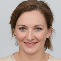 Joyful white adult female with medium  brown hair and grey eyes