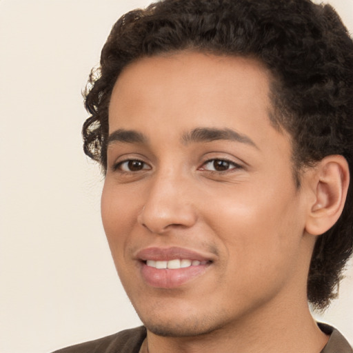 Joyful latino young-adult male with short  brown hair and brown eyes