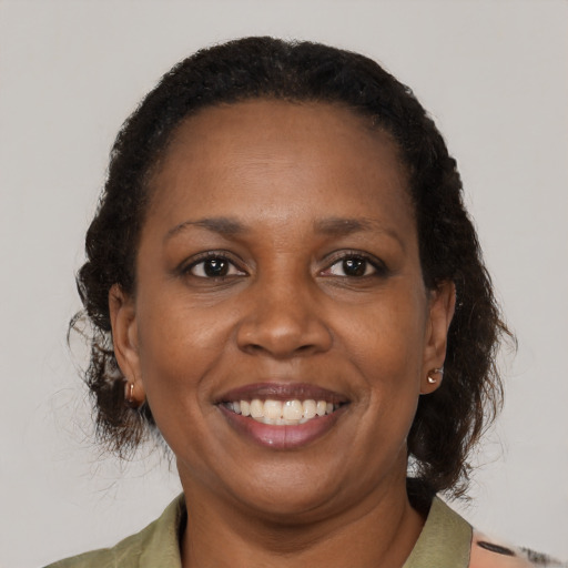 Joyful black adult female with medium  brown hair and brown eyes