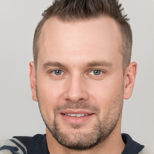 Joyful white young-adult male with short  brown hair and grey eyes