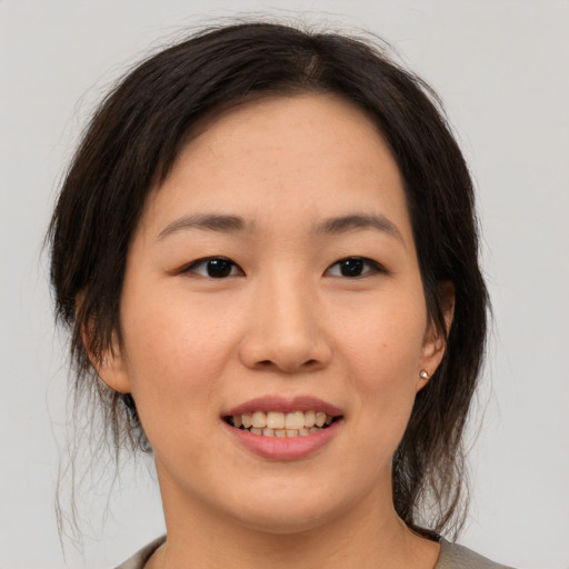 Joyful asian young-adult female with medium  brown hair and brown eyes