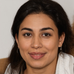 Joyful latino young-adult female with long  brown hair and brown eyes