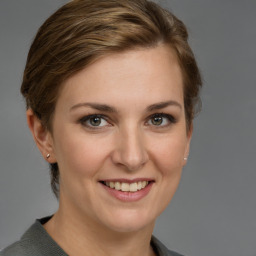 Joyful white young-adult female with medium  brown hair and grey eyes