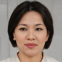 Joyful asian young-adult female with medium  brown hair and brown eyes