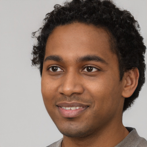 Joyful black young-adult male with short  black hair and brown eyes