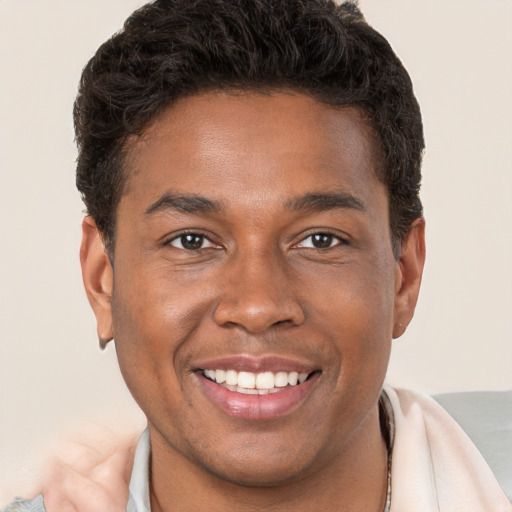 Joyful black young-adult male with short  brown hair and brown eyes