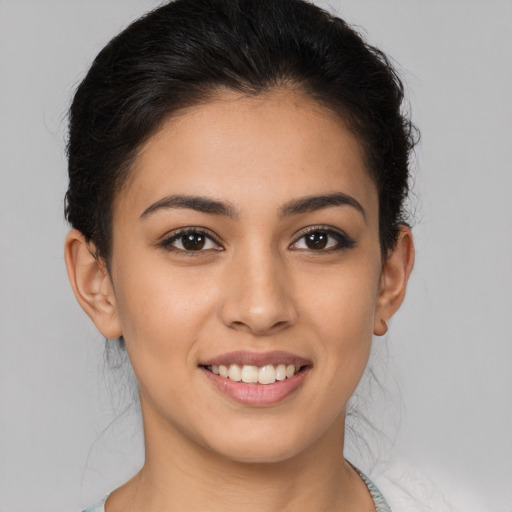 Joyful latino young-adult female with medium  brown hair and brown eyes