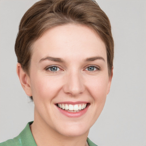 Joyful white young-adult female with short  brown hair and grey eyes