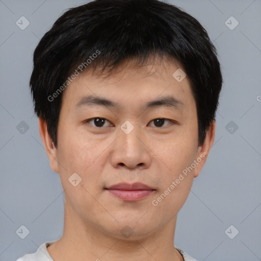 Joyful asian young-adult male with short  black hair and brown eyes