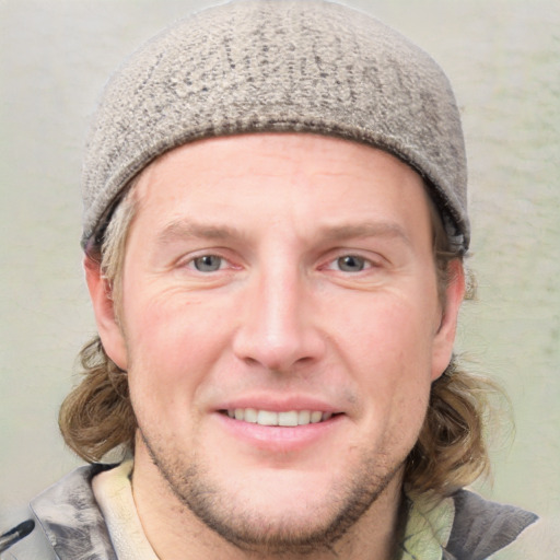 Joyful white young-adult male with short  brown hair and blue eyes