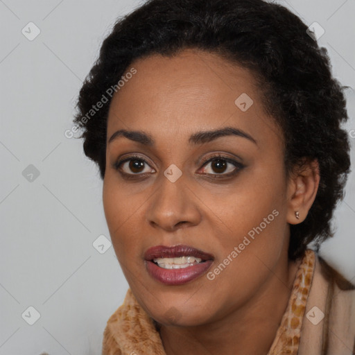 Joyful black young-adult female with long  black hair and brown eyes