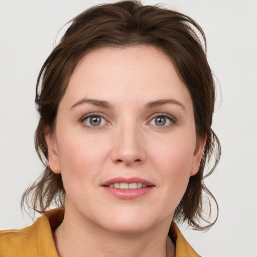 Joyful white young-adult female with medium  brown hair and blue eyes