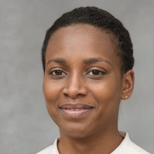 Joyful black young-adult female with short  black hair and brown eyes