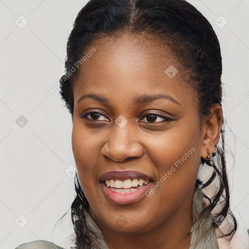 Joyful black young-adult female with long  brown hair and brown eyes