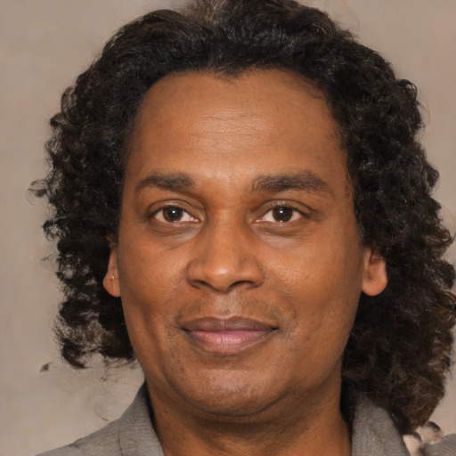 Joyful black adult male with medium  brown hair and brown eyes