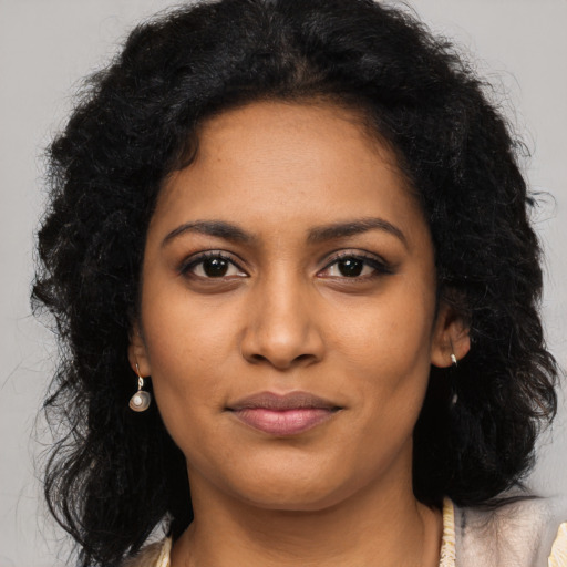 Joyful black young-adult female with long  black hair and brown eyes